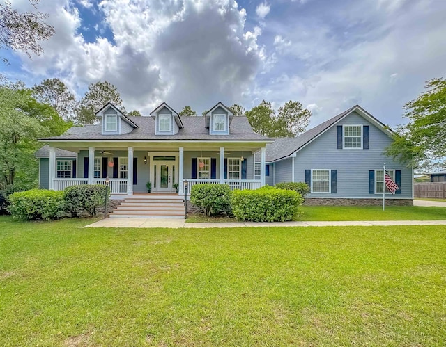 cape cod house featuring a porch and a front lawn