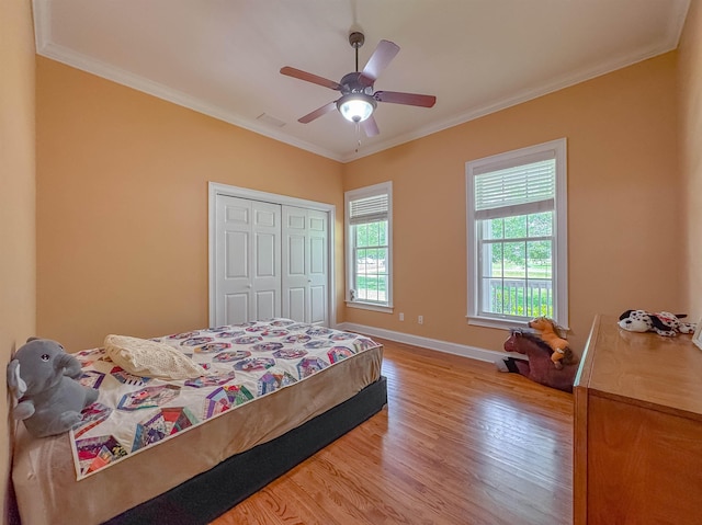 bedroom featuring visible vents, ornamental molding, light wood-style flooring, and a closet