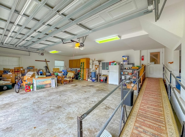 garage featuring a garage door opener and freestanding refrigerator