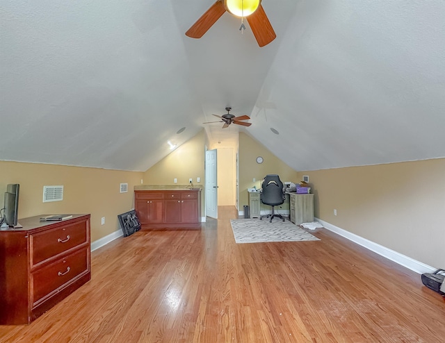 bonus room with a ceiling fan, visible vents, light wood-type flooring, baseboards, and lofted ceiling