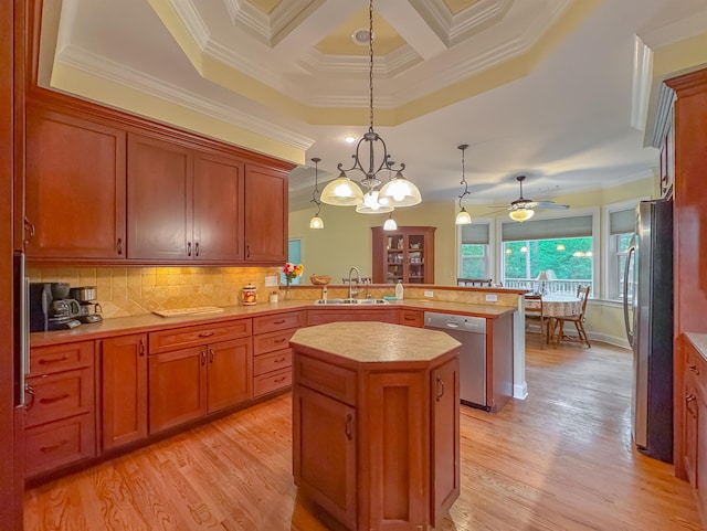 kitchen featuring a sink, a center island, stainless steel appliances, a peninsula, and ornamental molding