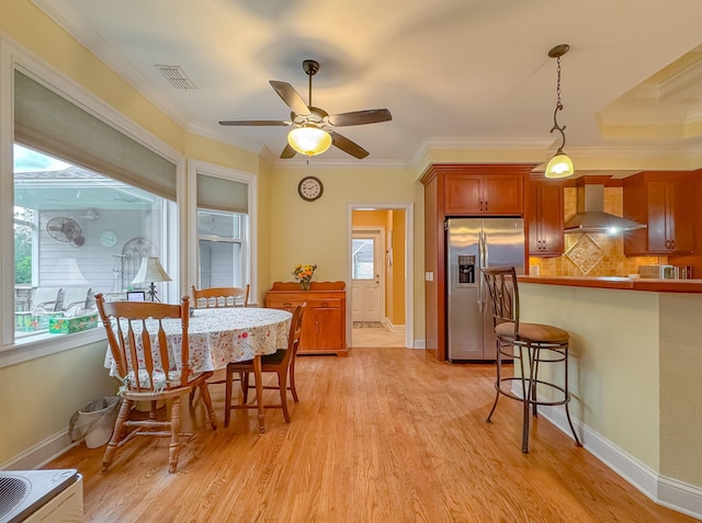 dining area with ceiling fan, visible vents, crown molding, light wood-type flooring, and baseboards