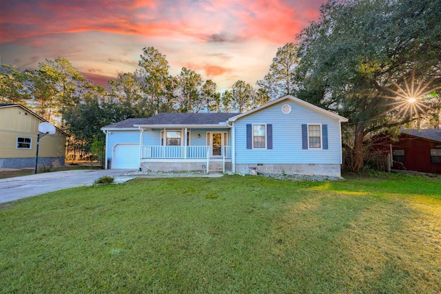 view of front of house with a lawn, covered porch, and a garage