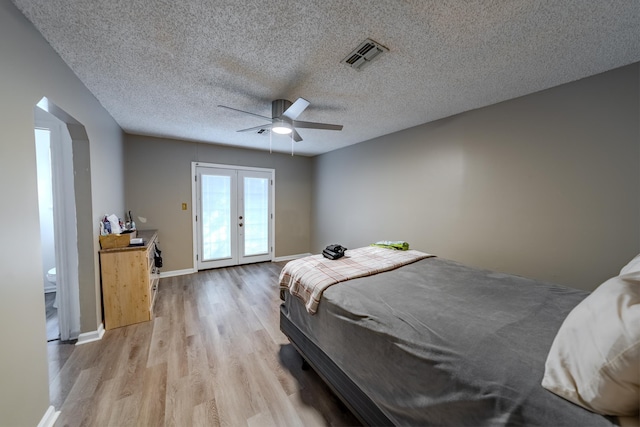 bedroom with ceiling fan, french doors, a textured ceiling, and light hardwood / wood-style floors