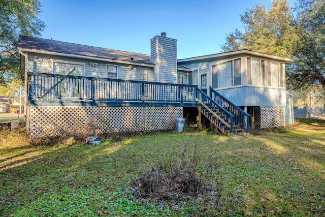 back of house featuring a wooden deck and a lawn