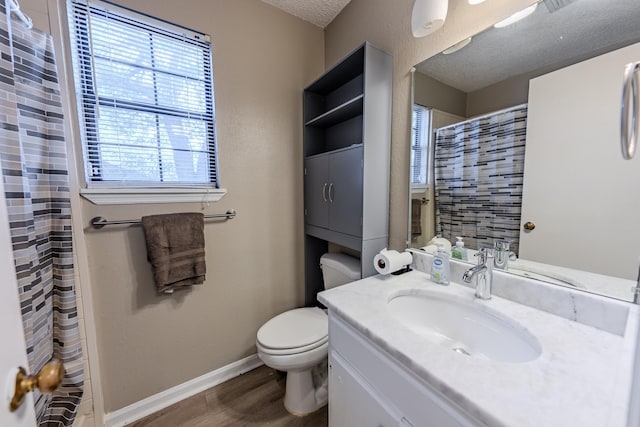 bathroom with toilet, a healthy amount of sunlight, hardwood / wood-style flooring, and vanity