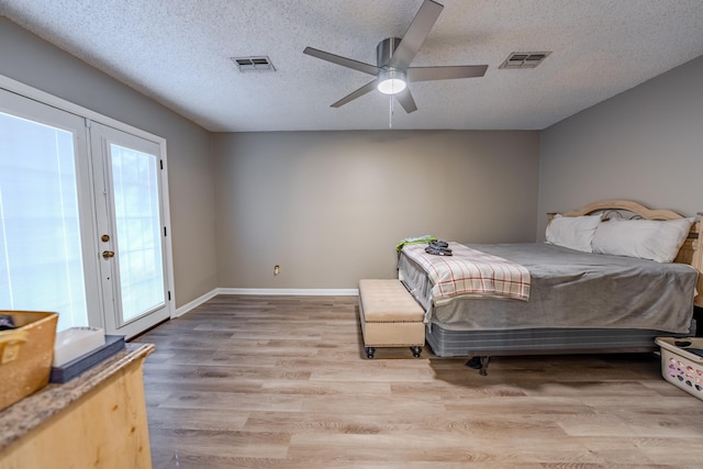 bedroom featuring ceiling fan, a textured ceiling, access to outside, and french doors