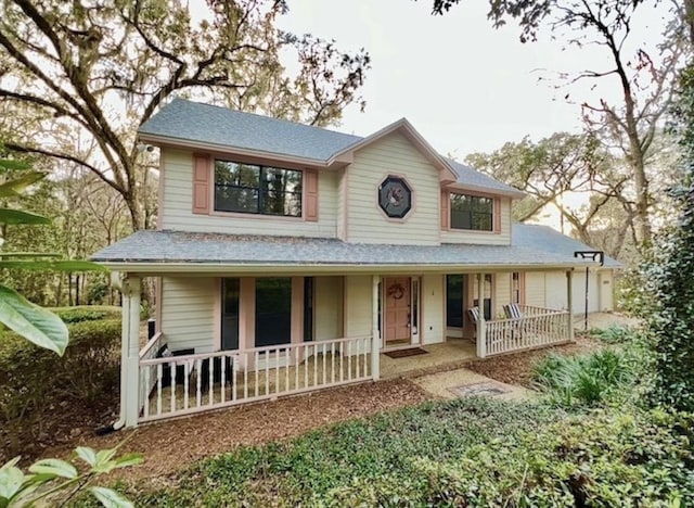 country-style home with a garage and a porch