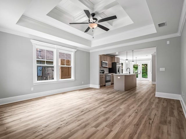 unfurnished living room featuring ornamental molding, a raised ceiling, ceiling fan, sink, and hardwood / wood-style flooring