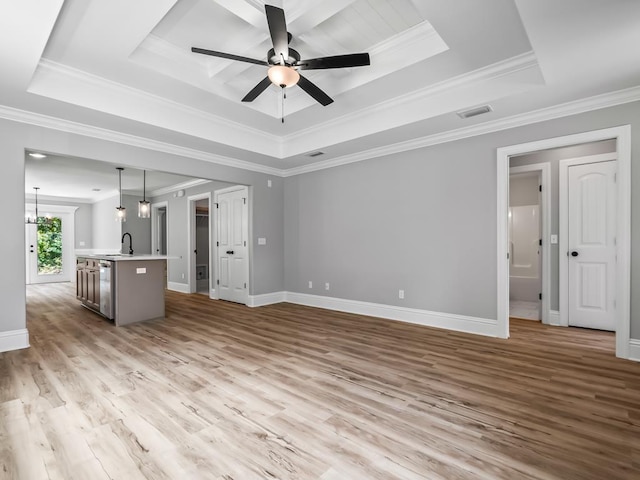 unfurnished living room with sink, light hardwood / wood-style floors, a tray ceiling, ceiling fan with notable chandelier, and ornamental molding