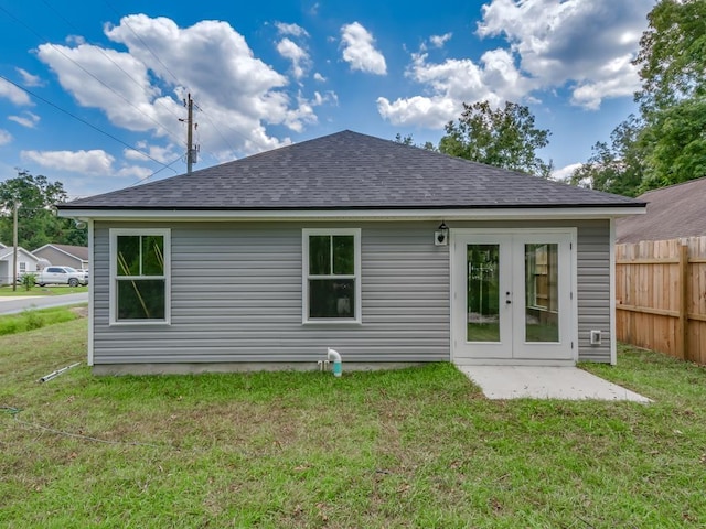 back of property featuring french doors and a lawn