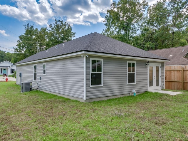 rear view of house with a lawn and central AC unit