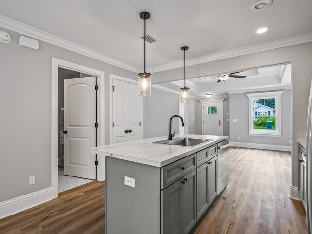 kitchen with gray cabinetry, a kitchen island with sink, sink, ceiling fan, and decorative light fixtures