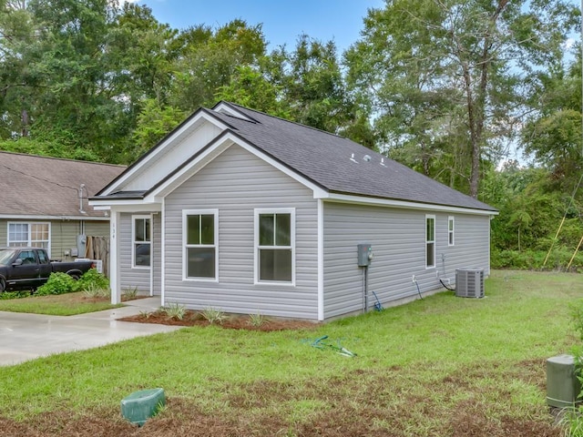 rear view of house featuring central AC and a yard