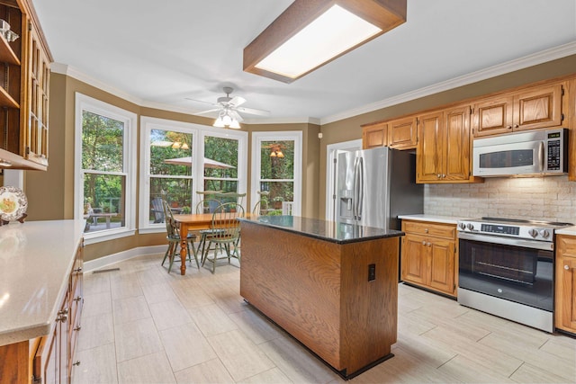 1961 Chatsworth Way, Tallahassee, FL 32309 - kitchen featuring stainless steel appliances, decorative backsplash, a ceiling fan, crown molding, and a kitchen island