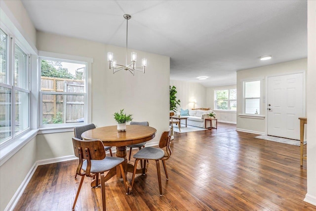 dining room featuring a notable chandelier, wood finished floors, and baseboards