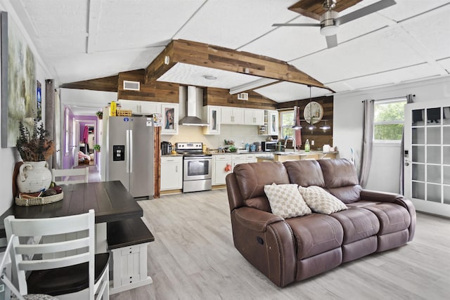 living room with visible vents, a ceiling fan, wood walls, light wood-style floors, and lofted ceiling with beams