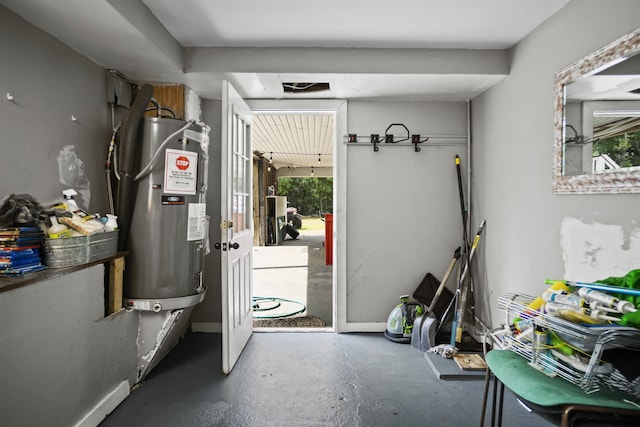 doorway to outside with water heater, baseboards, concrete flooring, and a healthy amount of sunlight