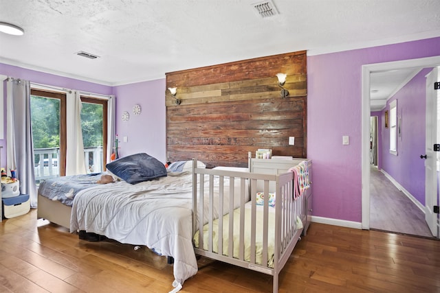 bedroom with baseboards, wood-type flooring, and visible vents