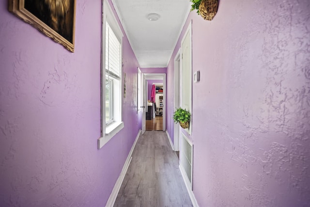 corridor featuring baseboards and light wood-style floors