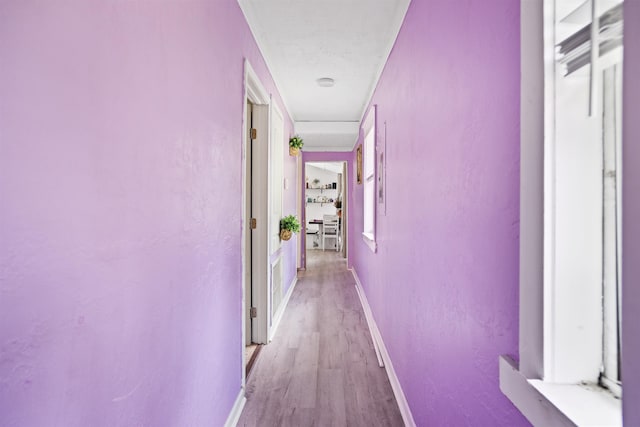 hall featuring baseboards and light wood finished floors
