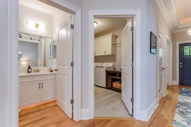 3837 Broadmore Ln, Tallahassee, FL 32308 - corridor featuring a sink, washer and clothes dryer, crown molding, light wood-style floors, and baseboards