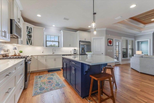 3837 Broadmore Ln, Tallahassee, FL 32308 - kitchen with stainless steel appliances, a breakfast bar, white cabinets, open floor plan, and light wood-type flooring