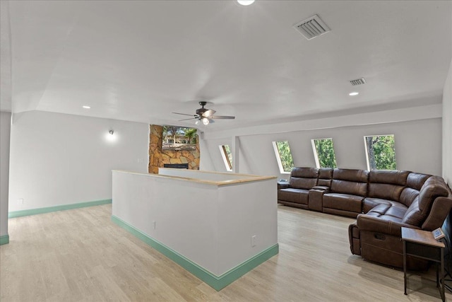 living room featuring a fireplace, light hardwood / wood-style floors, and ceiling fan