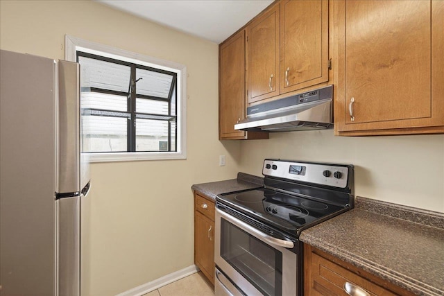 1515 Merry Oaks Ct, Tallahassee, FL 32303 - kitchen featuring appliances with stainless steel finishes, under cabinet range hood, dark countertops, brown cabinets, and light tile patterned flooring