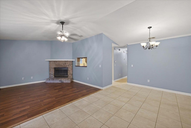 1515 Merry Oaks Ct, Tallahassee, FL 32303 - unfurnished living room featuring a chandelier, a brick fireplace, a ceiling fan, and wood finished floors
