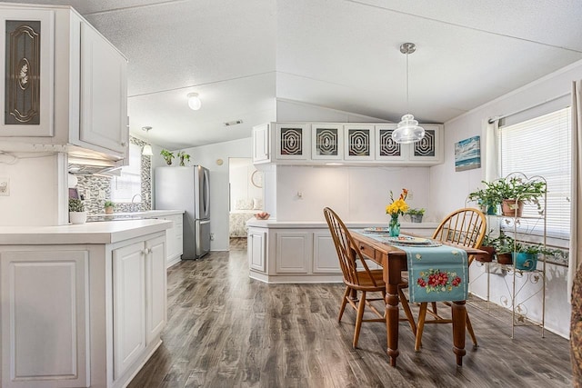 dining space featuring vaulted ceiling and dark wood-style flooring