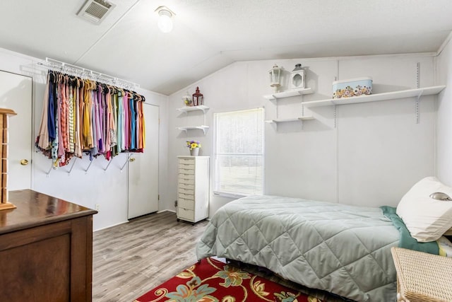 bedroom featuring light wood-type flooring and lofted ceiling