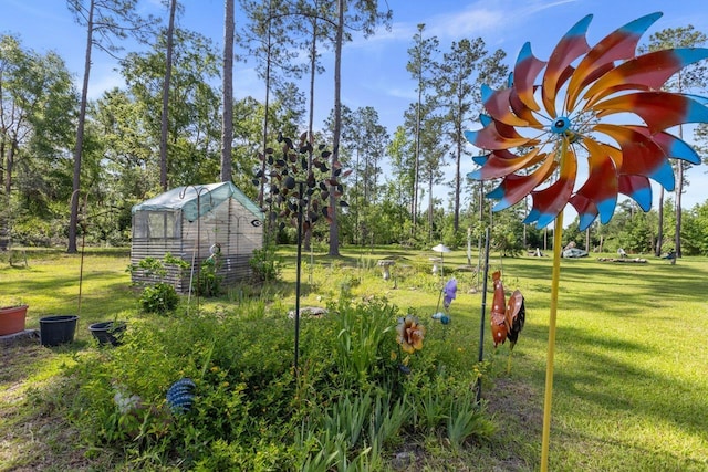 view of grassy yard with an outdoor structure, view of scattered trees, and a greenhouse