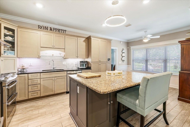 7277 White Clover Ct, Tallahassee, FL 32311 - kitchen with a sink, appliances with stainless steel finishes, a kitchen bar, light wood-style flooring, and a kitchen island