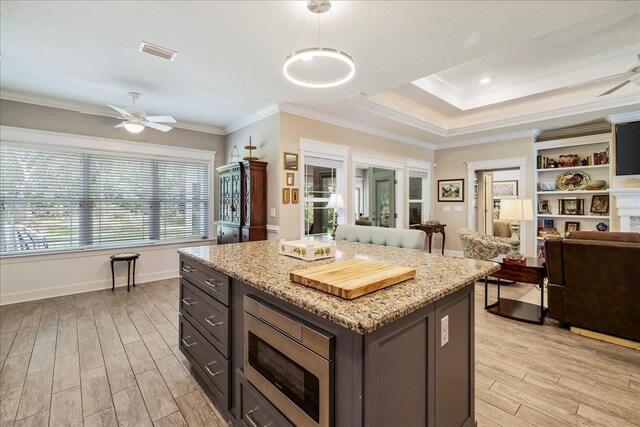 7277 White Clover Ct, Tallahassee, FL 32311 - kitchen with a ceiling fan, light wood-style flooring, stainless steel microwave, open floor plan, and ornamental molding