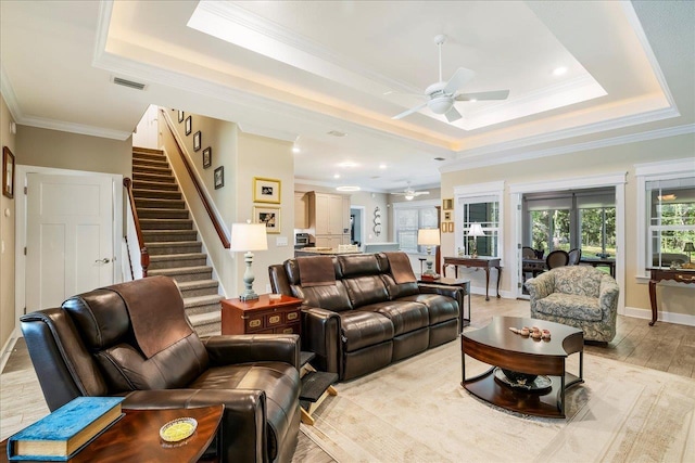7277 White Clover Ct, Tallahassee, FL 32311 - living room featuring ceiling fan, a tray ceiling, crown molding, stairway, and light wood-style flooring