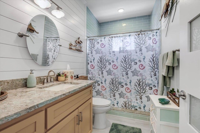 bathroom featuring vanity and wood walls