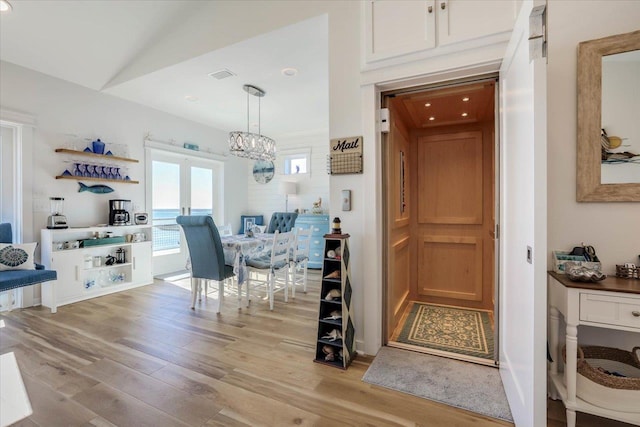 dining area with light hardwood / wood-style floors and vaulted ceiling