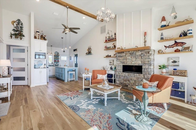 living room featuring beam ceiling, high vaulted ceiling, light hardwood / wood-style floors, and ceiling fan with notable chandelier