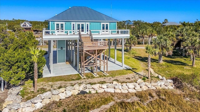 back of property with a yard, a patio area, french doors, and a carport