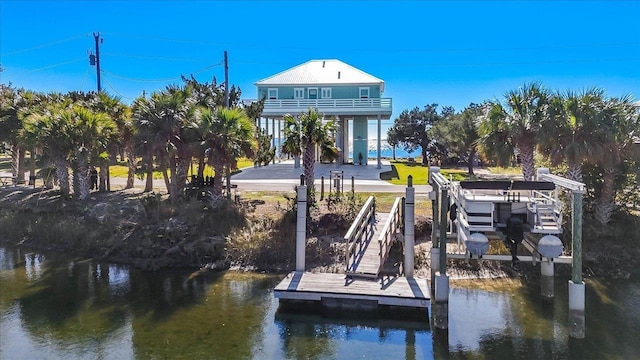 view of dock with a balcony and a water view