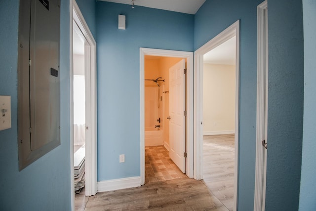 corridor featuring electric panel and light hardwood / wood-style flooring