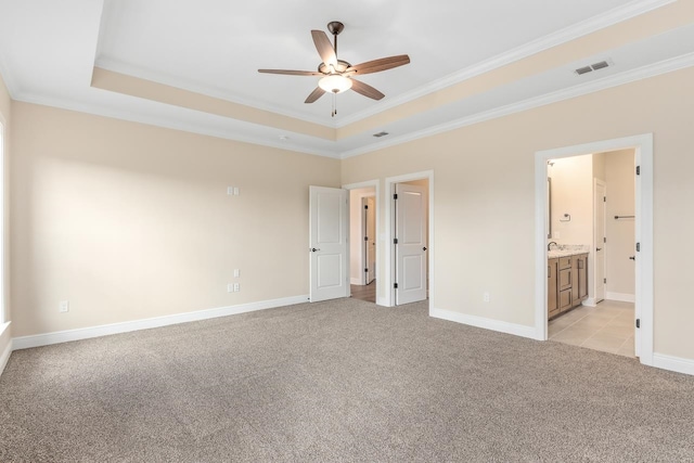 273 Springdale Dr, Crawfordville, FL 32327 - unfurnished bedroom with light carpet, crown molding, a tray ceiling, and connected bathroom