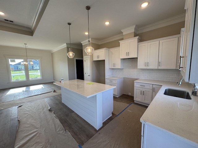 273 Springdale Dr, Crawfordville, FL 32327 - kitchen with crown molding, dark wood finished floors, tasteful backsplash, white cabinetry, and a kitchen island
