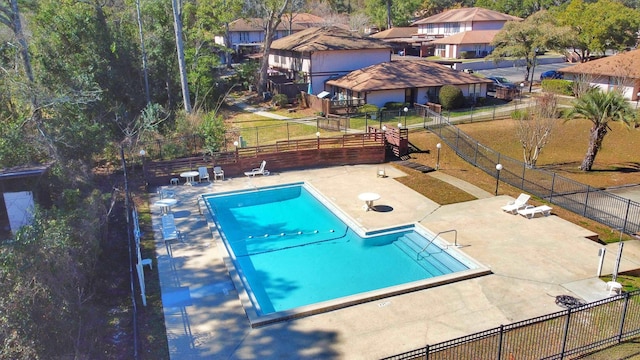 community pool with fence and a patio