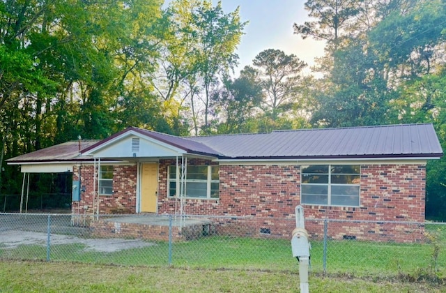 single story home featuring metal roof, a front yard, and a fenced front yard