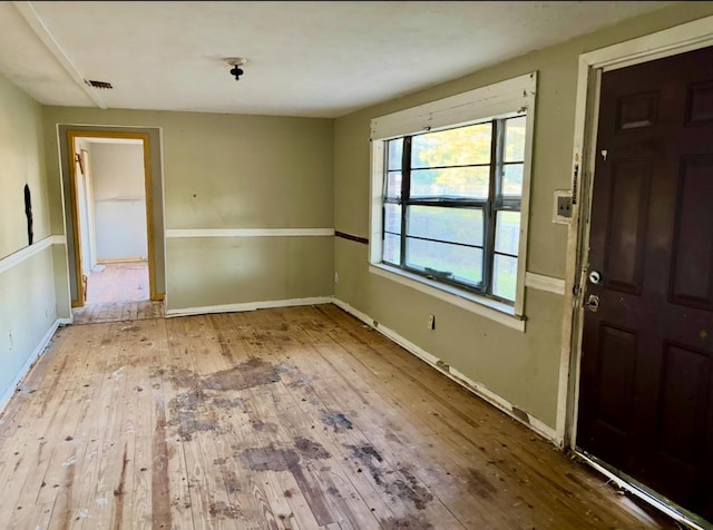 interior space featuring wood-type flooring, visible vents, and baseboards