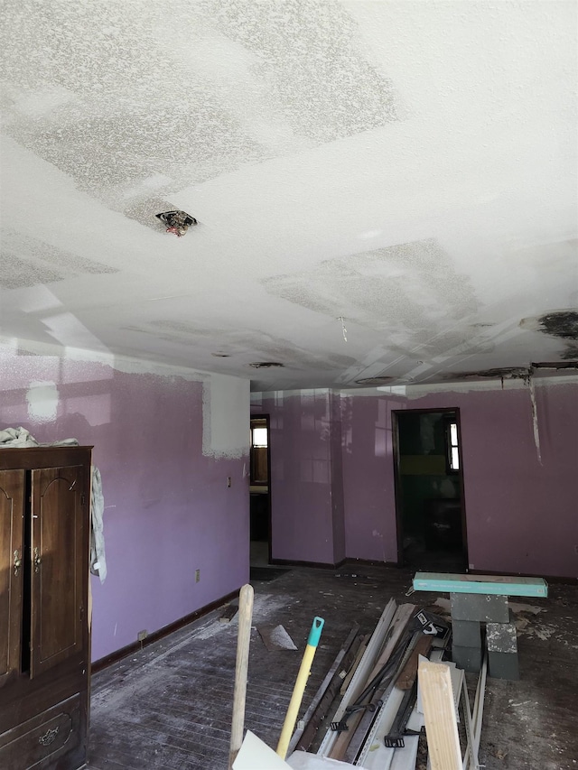 empty room featuring a textured ceiling and baseboards