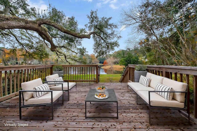 deck with a water view and an outdoor living space with a fire pit