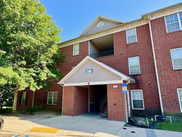 3000 S Adams St Unit 234, Tallahassee, FL 32301 - view of front of home featuring driveway, a garage, brick siding, and a balcony
